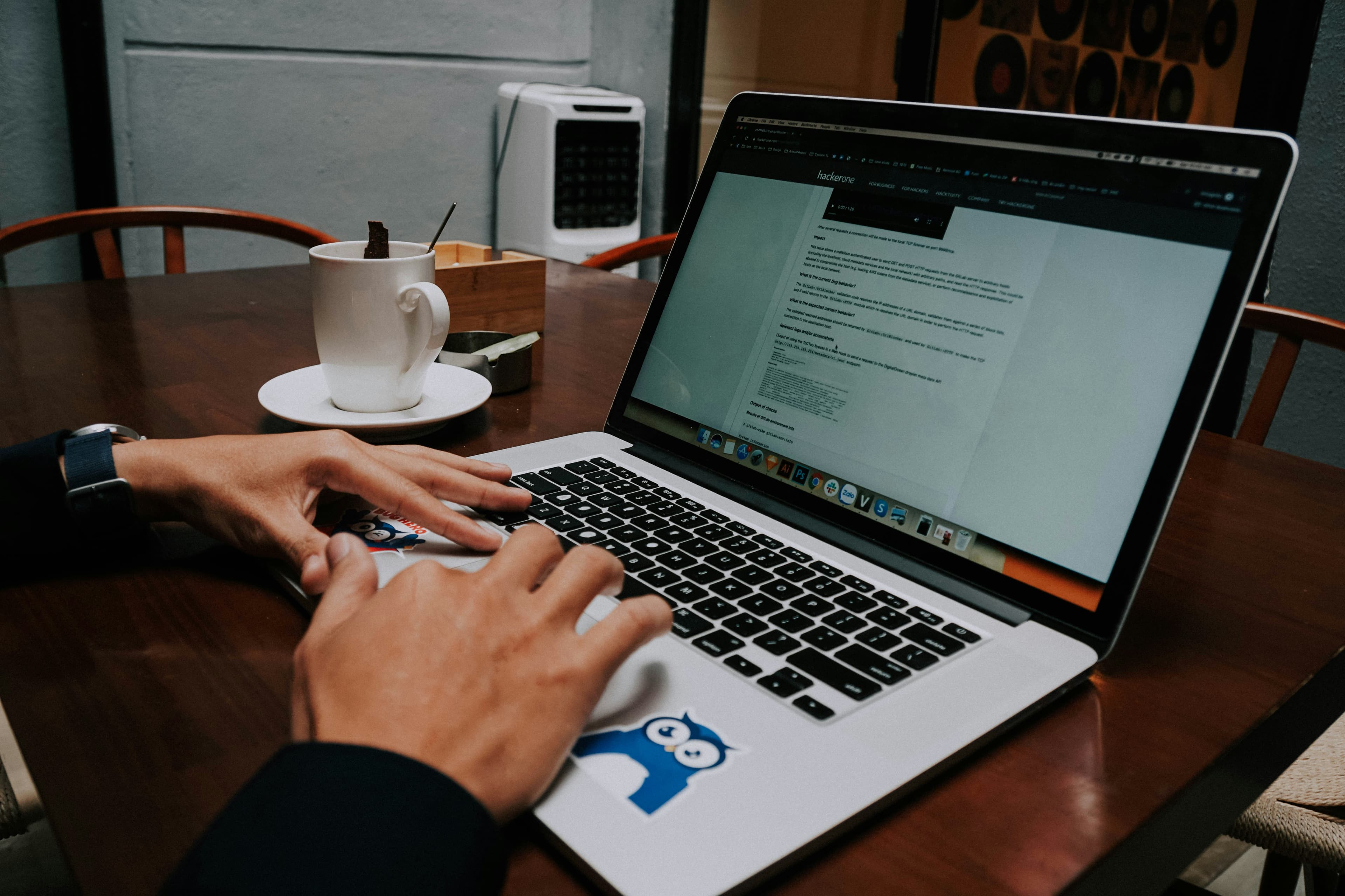 Person typing on laptop at a clean desk with a coffee cup, representing reaching out and communication